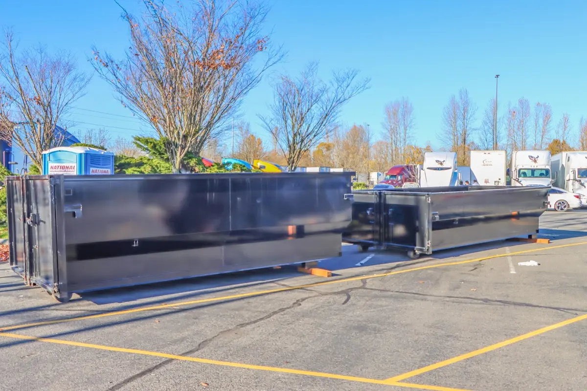 Professional dumpster rental service with roll-off container on residential driveway in Schoolcraft